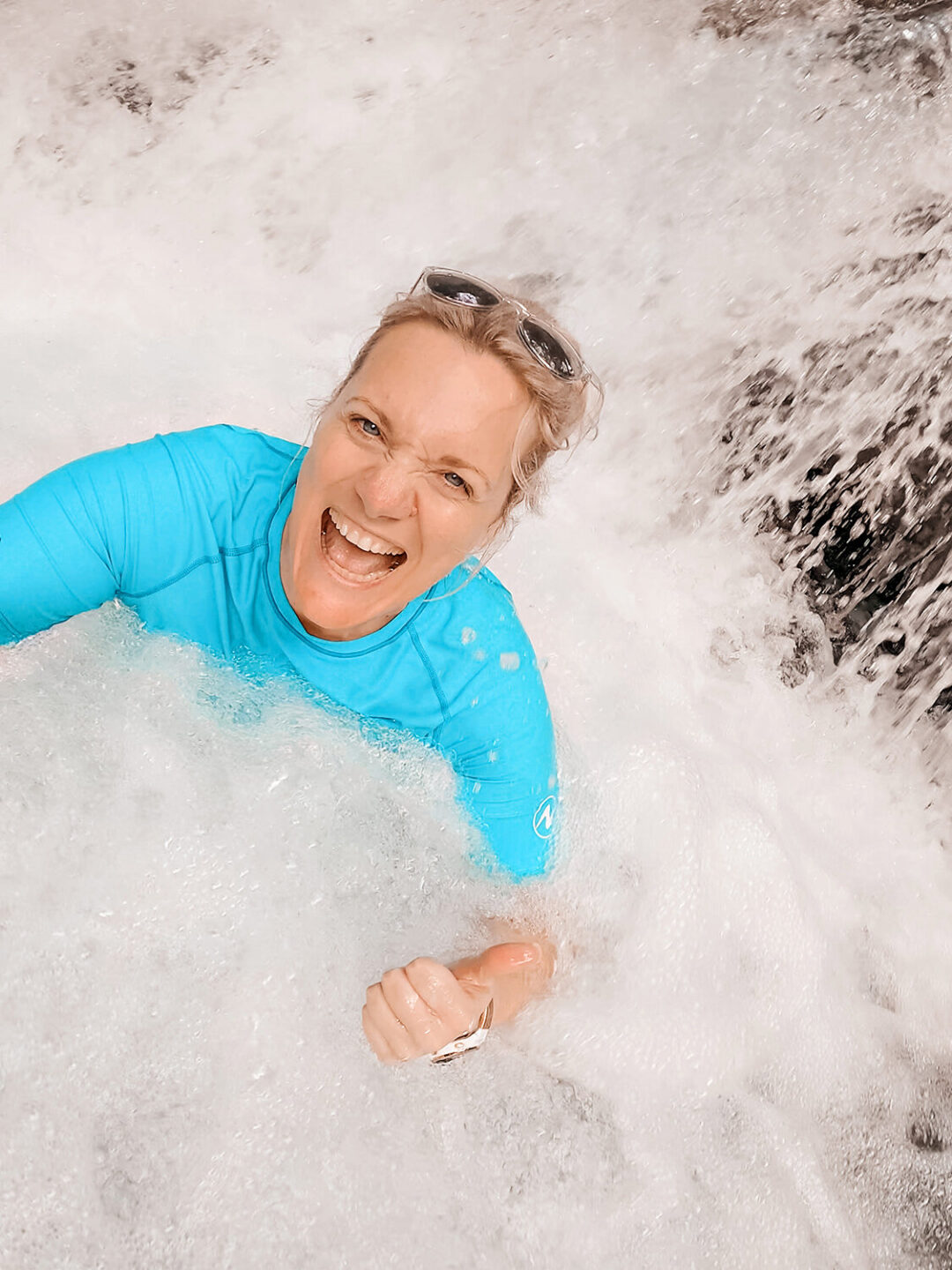 healing after gout at young age - woman happy and smiling in a waterfall