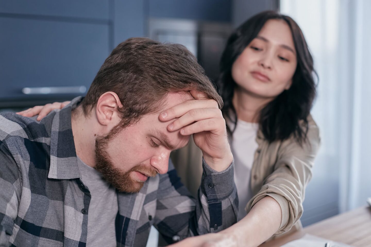A husband stressed out, head in hands, taking FMLA for gout caregivers