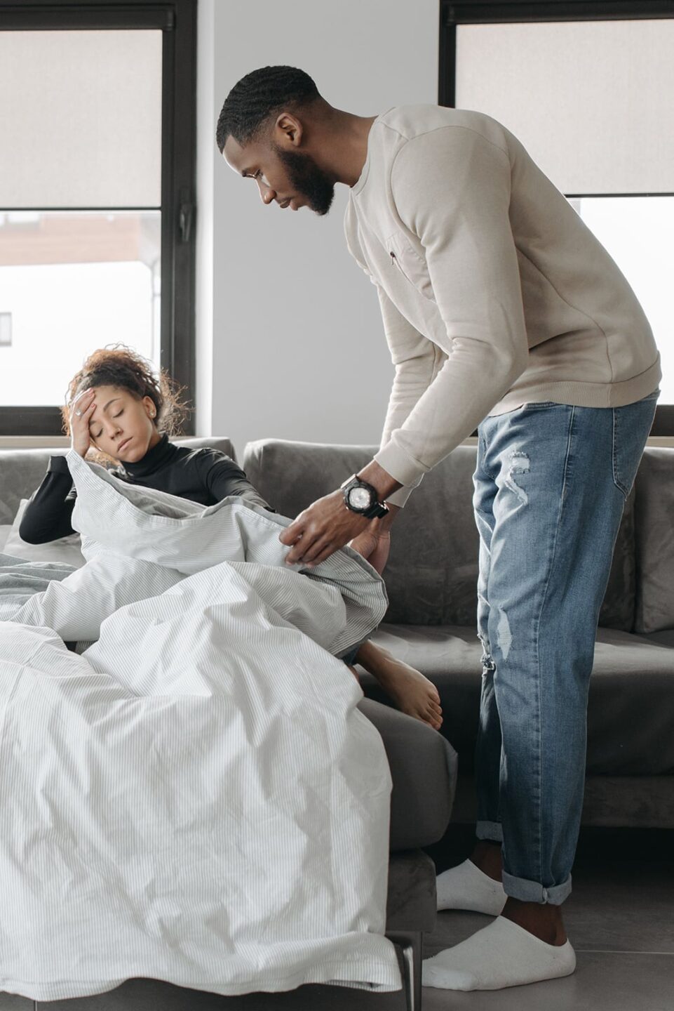 FMLA for Gout Caregivers, a husband helping his wife get comfortable on the couch