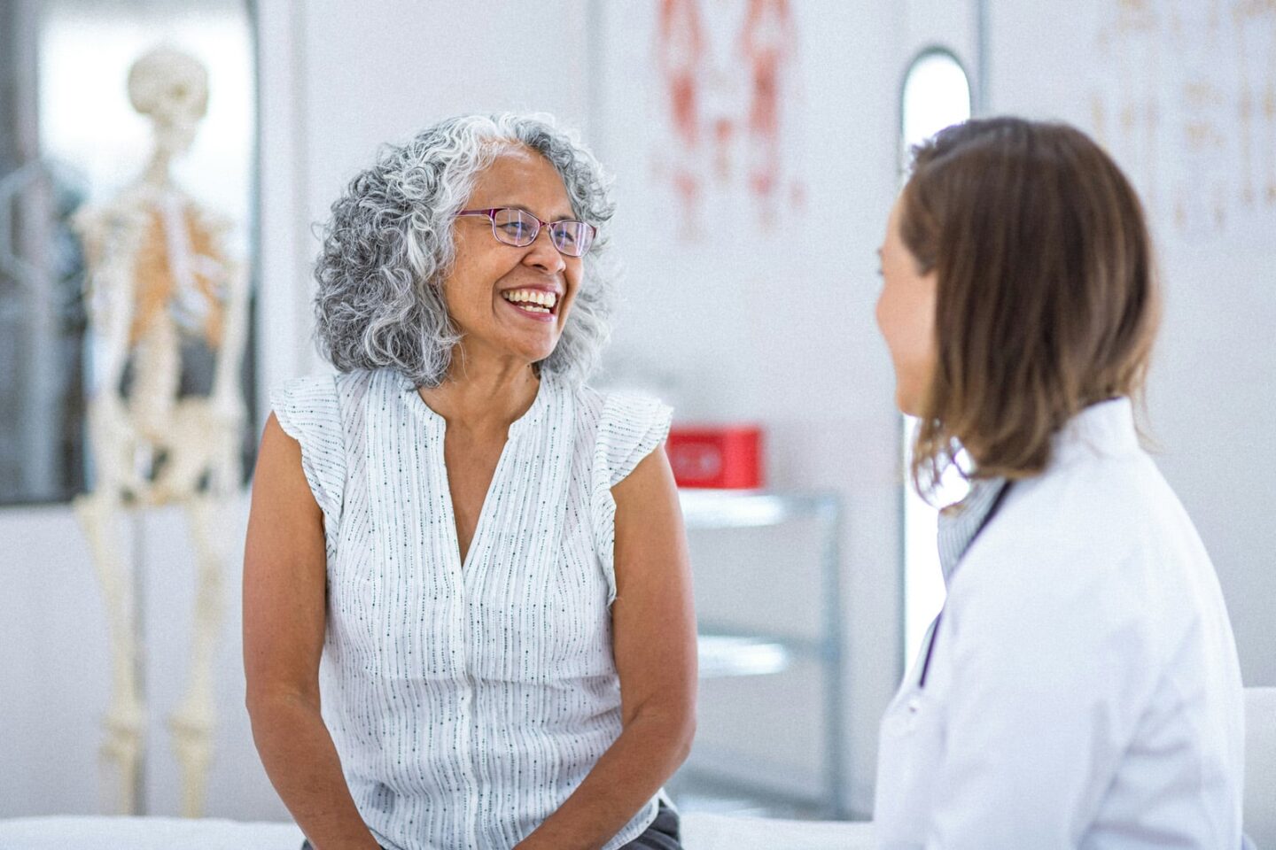 an older woman smiling with her doctor in clinic 